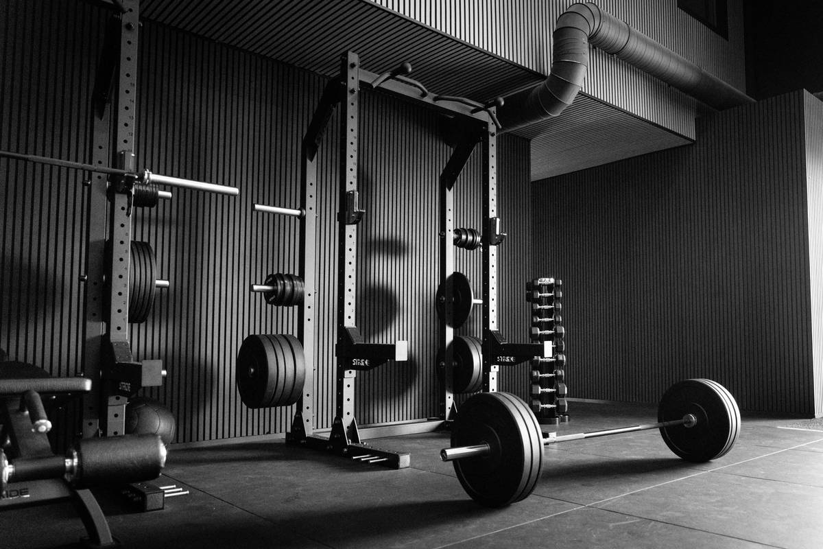 strength training over fitness how much: man over 40 performing barbell squat with proper form